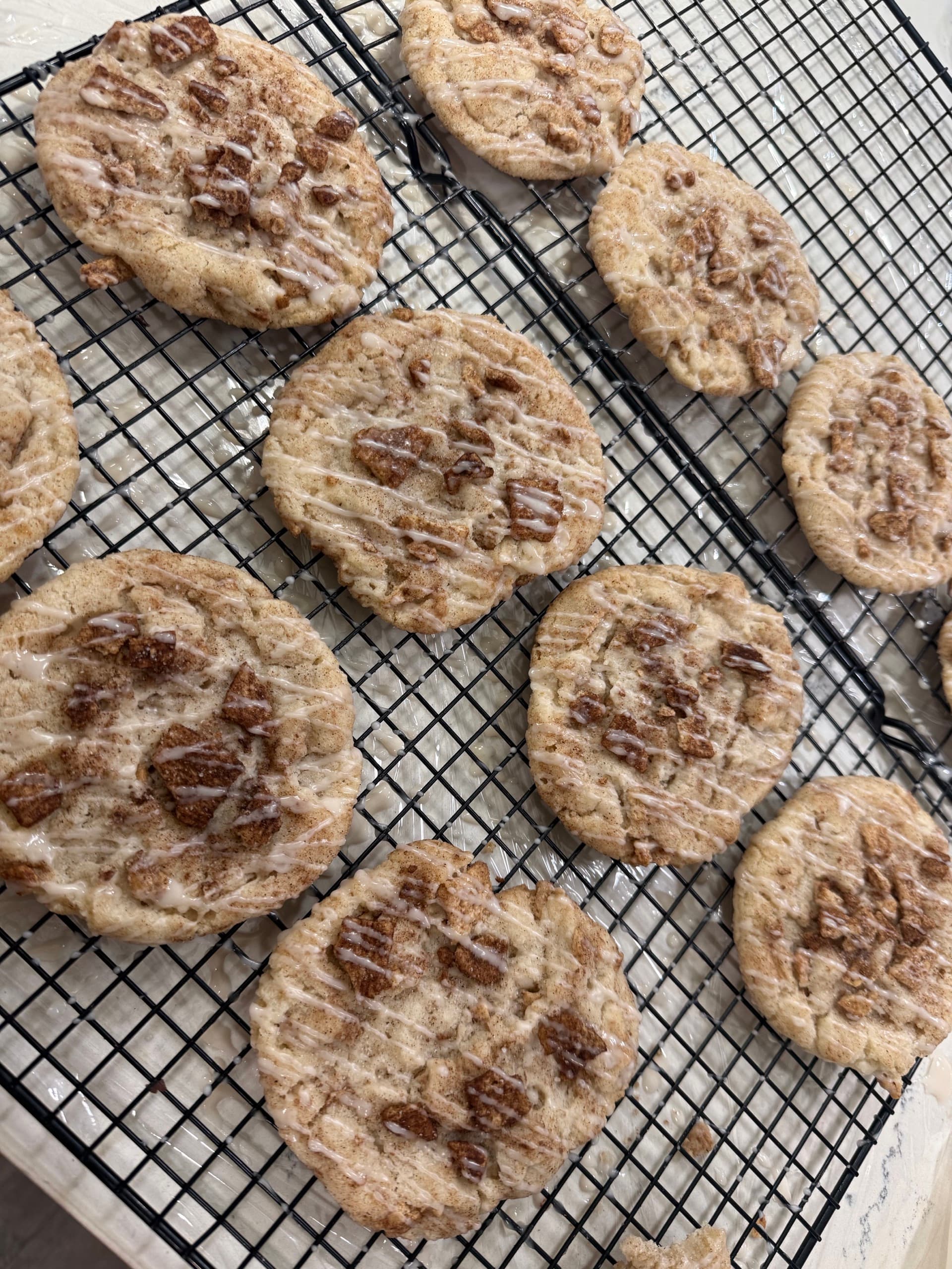 Freshly glazed homemade cookies cooling on a wire rack
