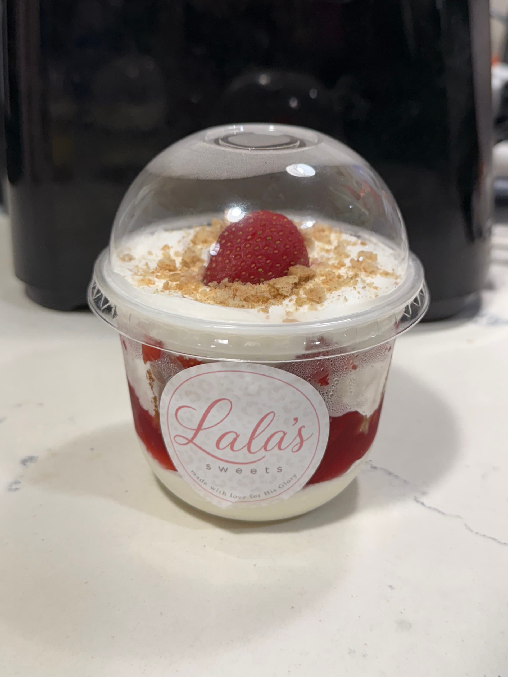 A strawberry parfait in a Lala's Sweets branded cup